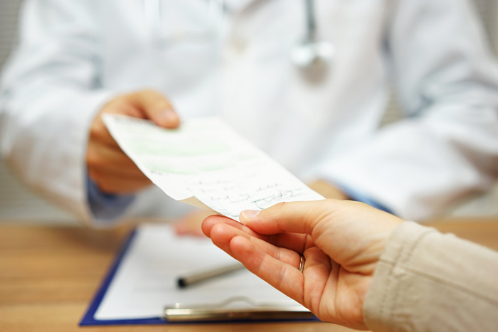 doctor handing patient written prescription - opioid addiction