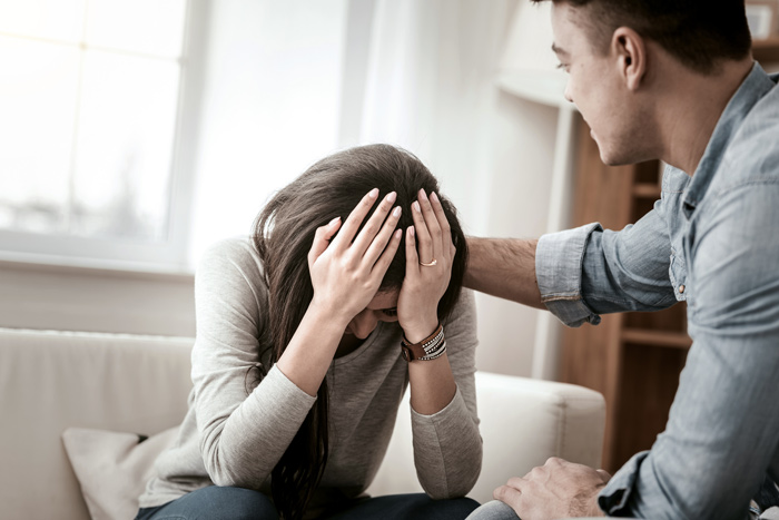 upset woman being consoled by man - top causes of relapse