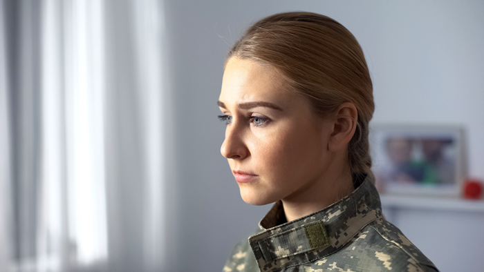 female soldier looking sad in therapist or rehab office - veterans and substance use disorder
