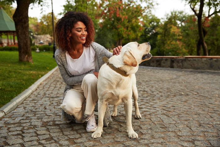 beautiful Black woman outside with her dog - cravings