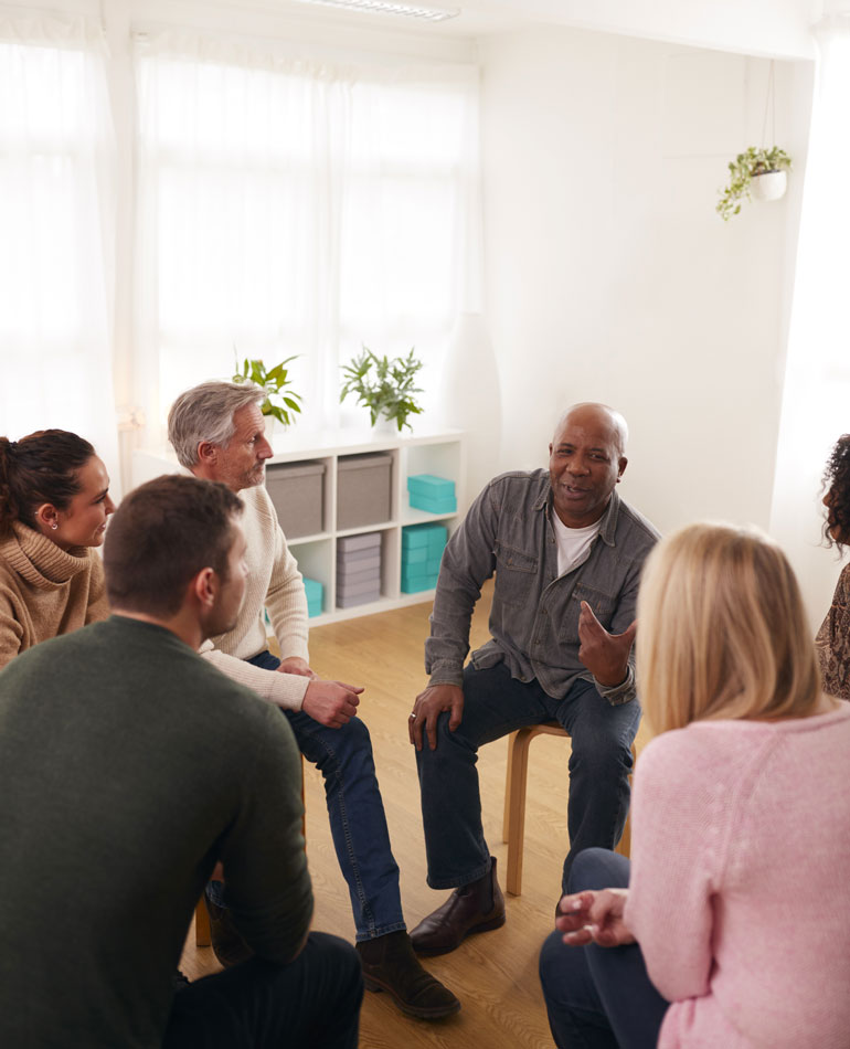 diverse group of adults talking in group therapy - intensive outpatient program - IOP